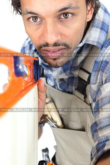 Tradesman using a bubble level. Стоковое фото, агентство Ingram Publishing / Фотобанк Лори