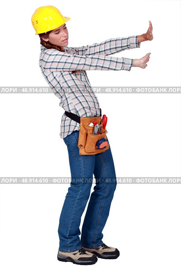 Tradeswoman pushing up against an invisible wall. Стоковое фото, агентство Ingram Publishing / Фотобанк Лори