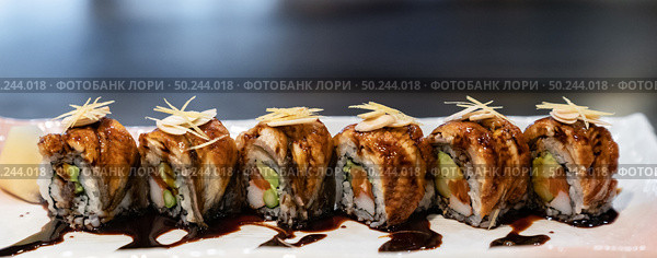 Traditional japanese food cuisine Unagi roll, japanese ell serve with japanese rice and avocado with special sauce. Panorama crop for web banner. Стоковое фото, агентство Ingram Publishing / Фотобанк Лори