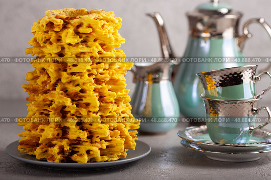Traditional lithuanian cake, sakotis, is served on a gray table with a tea set. Стоковое фото, фотограф Елена Дмитриева / Фотобанк Лори