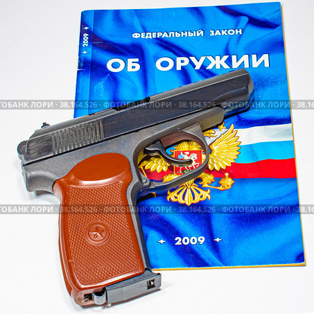 Травматический пистолет крупным планом на брошюре "Федеральный закон РФ "Об оружии" (2022 год). Редакционное фото, фотограф Анна Аникова / Фотобанк Лори