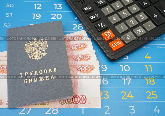 Трудовая книжка, калькулятор и российские деньги лежат на листах календаря. Стоковое фото, фотограф Цибаев Алексей / Фотобанк Лори