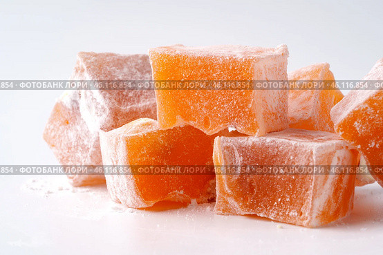 Turkish delight cubes in orange flavor arranged on a plain background for dessert enthusiasts. Стоковое фото, фотограф Сергей Толмачёв / Фотобанк Лори