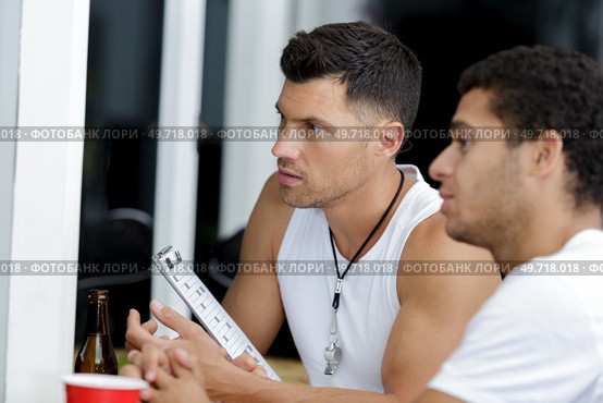 two concentrated men having a beer on the gym. Стоковое фото, агентство Ingram Publishing / Фотобанк Лори