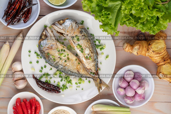Two cooked mackerel, placed in a white dish, sprinkled with spring onions. Стоковое фото, агентство Ingram Publishing / Фотобанк Лори