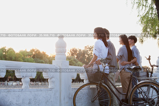 Two couples by HouHai Lake with Bicycles in Beijing. Стоковое фото, агентство Ingram Publishing / Фотобанк Лори