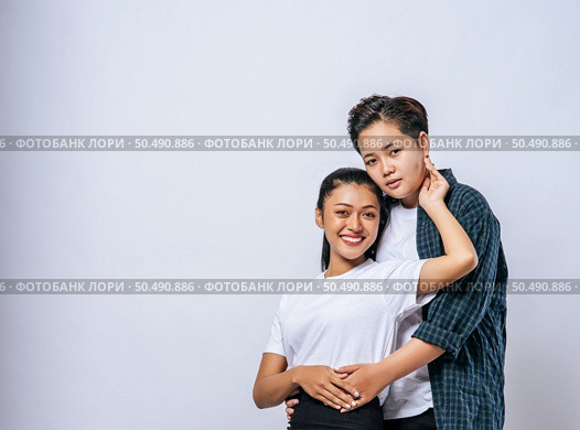 Two female lovers standing and hugging from behind. Стоковое фото, агентство Ingram Publishing / Фотобанк Лори