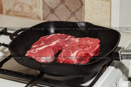 Two fresh raw meat of beef steak Prime Black Angus Chuck roll steak grilled in pan on gas stove. Стоковое фото, фотограф Ирина Буракова / Фотобанк Лори