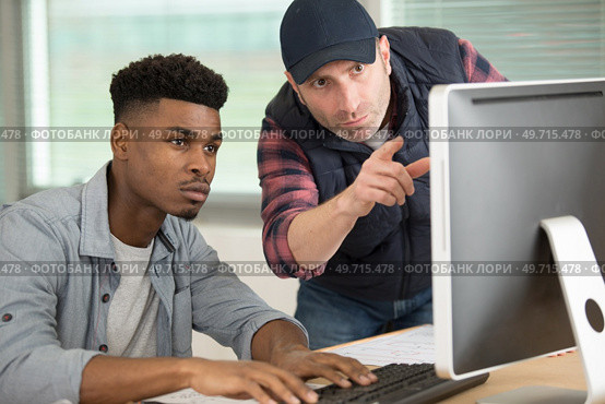 two men conferring while looking at computer screen. Стоковое фото, агентство Ingram Publishing / Фотобанк Лори