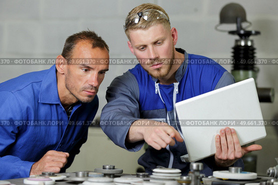 two men doing induction hardening in a factory. Стоковое фото, агентство Ingram Publishing / Фотобанк Лори