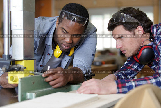 two men holding timber on woodworking machine. Стоковое фото, агентство Ingram Publishing / Фотобанк Лори