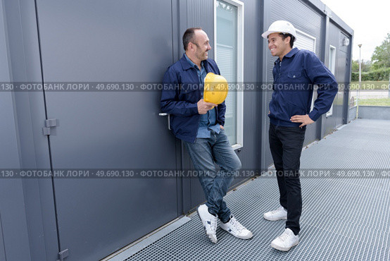 two men in safety helmets vests and working clothes. Редакционное фото, агентство Ingram Publishing / Фотобанк Лори