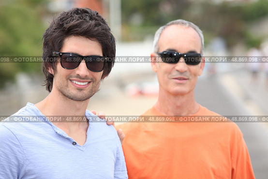Two men of different generations wearing sunglasses and t-shirts. Стоковое фото, агентство Ingram Publishing / Фотобанк Лори