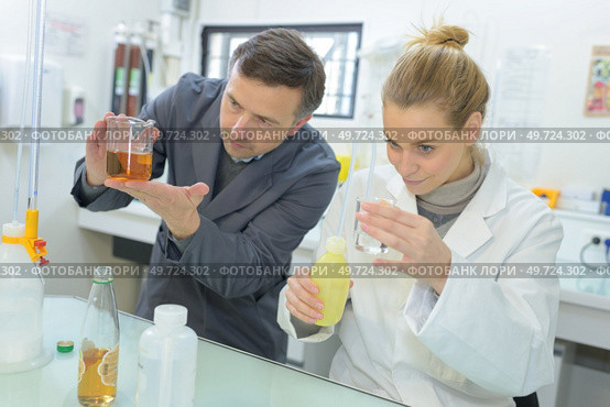two scientists making experiments with different liquids. Стоковое фото, агентство Ingram Publishing / Фотобанк Лори
