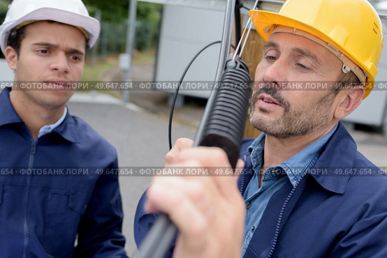 two technicians installing an equipment. Стоковое фото, агентство Ingram Publishing / Фотобанк Лори
