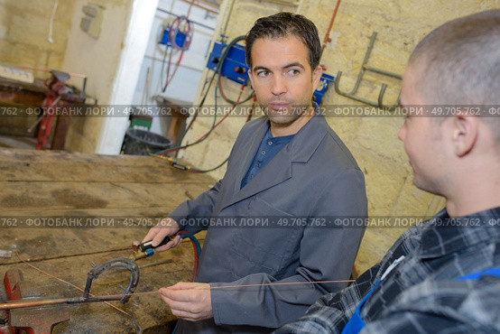 two worker in factory on work bench in conversation. Стоковое фото, агентство Ingram Publishing / Фотобанк Лори