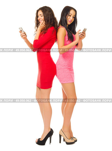 Two young girls with mobile phones isolated. Стоковое фото, агентство Ingram Publishing / Фотобанк Лори