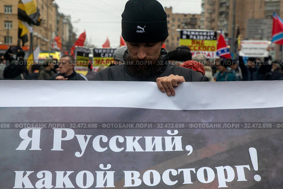 Участник Русского марша на улице Маршала Бирюзова держит баннер в городе Москве, Россия 4 ноября 2019. Редакционное фото, фотограф Николай Винокуров / Фотобанк Лори