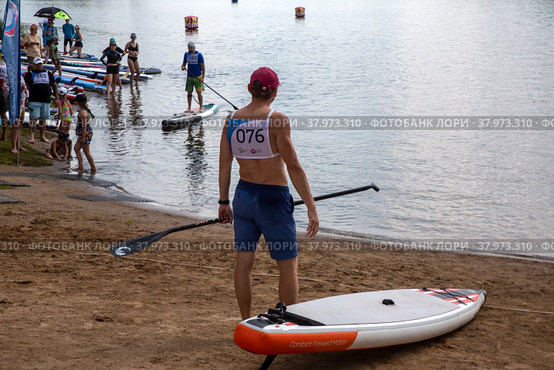 Участник Sup Fest Yaroslavl во время всероссийских спортивных соревнований по серфингу в дисциплине "Доска с веслом" в городе Ярославль, Россия (2022 год). Редакционное фото, фотограф Николай Винокуров / Фотобанк Лори
