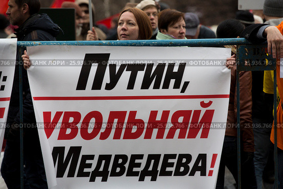 Участница митинга КПРФ на Площади Революции в городе Москве держит плакат с надписью "Путин, увольняй Медведева!" (2017 год). Редакционное фото, фотограф Николай Винокуров / Фотобанк Лори