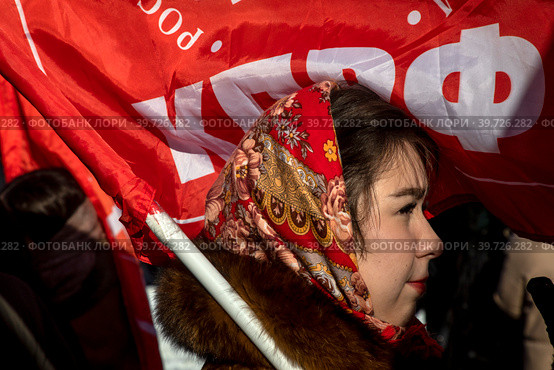 Участница митинга партии КПРФ приуроченного ко Дню защитника Отечества на площади Революции в центре города Москвы, Россия (2023 год). Редакционное фото, фотограф Николай Винокуров / Фотобанк Лори