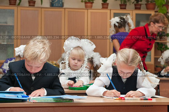 Учительница помогает первоклассникам на уроке (2009 год). Редакционное фото, фотограф Кекяляйнен Андрей / Фотобанк Лори
