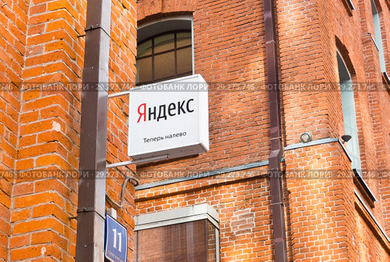 Указатель "Яндекс теперь налево". Деловой квартал «Красная Роза». Солнечный день. Москва (2018 год). Редакционное фото, фотограф E. O. / Фотобанк Лори