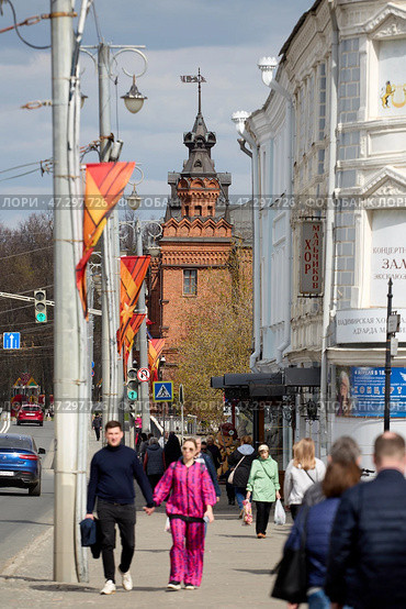 Улица города Владимир, Прохожие на тротуаре, Кирпичная башня на горизонте, Городской пейзаж с людьми, Владимирский проспект, Городская суета, Весенний город (2024 год). Редакционное фото, фотограф Сергей Расторгуев / Фотобанк Лори