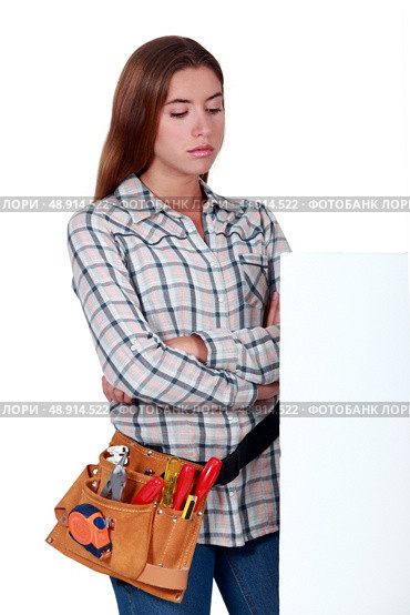 Unhappy woman standing behind a blank sign. Стоковое фото, агентство Ingram Publishing / Фотобанк Лори