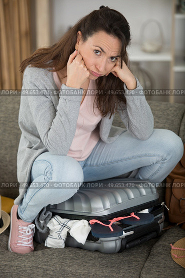 upset traveler woman sitting on luggage. Стоковое фото, агентство Ingram Publishing / Фотобанк Лори