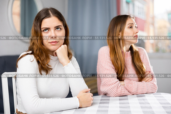 Upset woman sitting at home table with disgruntled woman behind. Стоковое фото, фотограф Яков Филимонов / Фотобанк Лори