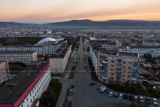 Утренний городской пейзаж. Вид с воздуха на город на рассвете. Вид сверху на здания и пустую улицу. Сопки вдалеке. Улица Парковая, город Магадан, Магаданская область, Дальний Восток России. Стоковое фото, фотограф Андрей Степанов / Фотобанк Лори