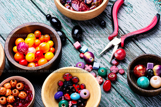 Variety of shapes and colors beads to make a bead necklace.Handcraft. Colorful beads in wooden bowls. Стоковое фото, агентство Ingram Publishing / Фотобанк Лори