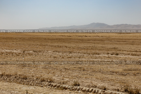 Vast arid landscape of Kunduz Province highlighting the barren terrain and distant mountains (2024 год). Стоковое фото, фотограф Михаил Пряхин / Фотобанк Лори