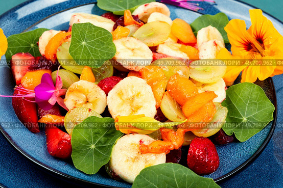 Vegetarian summer salad of fresh fruits and nasturtium leaves. Close up.. Fruit salad with nasturtium. Стоковое фото, агентство Ingram Publishing / Фотобанк Лори