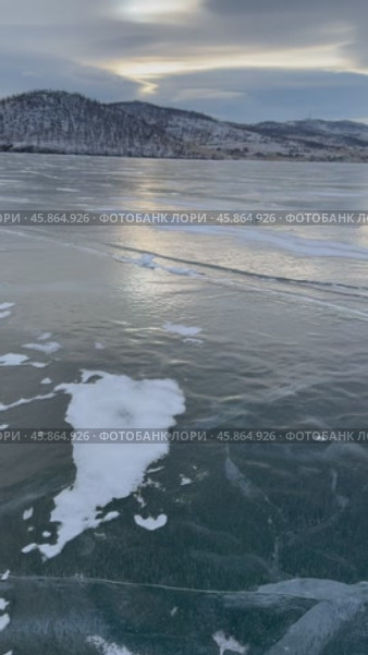 Vertical video of Baikal Lake in Desember sunset. Panoramic view of frozen Kurkut bay. Beautiful winter landscape. Natural backgriund. Стоковое видео, видеограф Виктория Катьянова / Фотобанк Лори