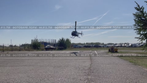 Вертолет Robinson R44 заходит на посадку и приземляется на размеченную площадку. Аэродром "Мячково", аэроклуб "Кондор-М" Редакционное видео, видеограф Щеголева Ольга / Фотобанк Лори