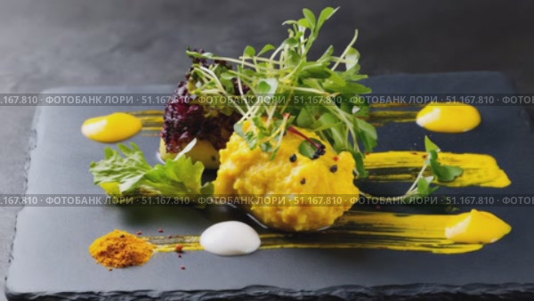 Vibrant yellow puree adorning black slate plate, complemented by purple beetroot, delicate microgreens, artistic sauce drizzles, contrasting culinary color composition. Стоковое AI-видео, аниматор Юрий Поздников / Фотобанк Лори