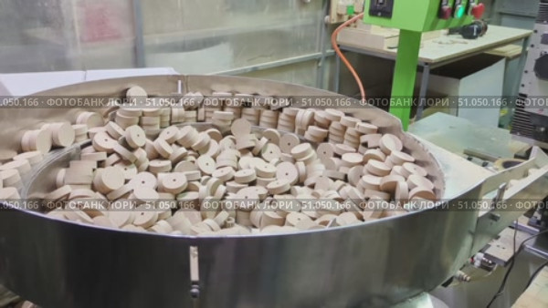 Vibrating device mechanism for automatic sorting and feeding of small round wooden discs in woodworking process. Стоковое видео, видеограф Елена Никишина / Фотобанк Лори
