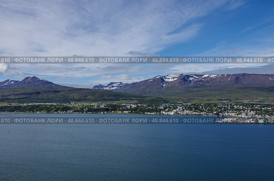 Вид на Акюрейри (Akureyri) с восточного берега Эйяфьордура (Eyjafjordur ) в Исландии - Эйяфьордур является самым длинным фьордом в Исландии. Он расположен в центральной части северной части страны. Стоковое фото, фотограф Дымов Игорь / Фотобанк Лори