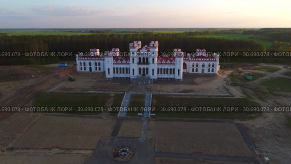 Вид на отреставрированный  старинный замок-дворец Пусловских апрельским вечером (съемка с квадрокоптера). Коссово, Белоруссия (2019 год). Стоковое видео, видеограф Виктор Карасев / Фотобанк Лори