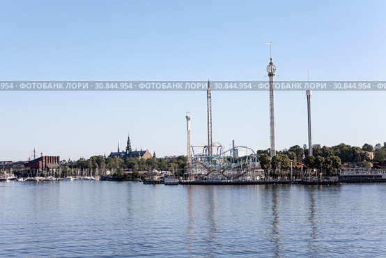 Вид со стороны залива на парк развлечений Грёна Лунд (Grona Lund). Расположен на острове Djurgarden, Стокгольм, Швеция. (2018 год). Редакционное фото, фотограф Кекяляйнен Андрей / Фотобанк Лори