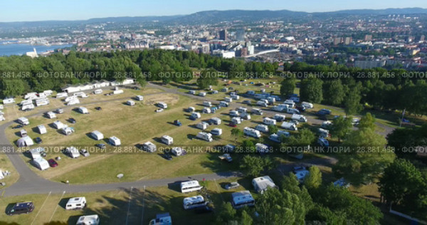 Вид сверху на Осло и кемпинг Ekeberg, заполненный автодомами и палатками. Раннее утро, Норвегия (2018 год). Стоковое видео, видеограф Кекяляйнен Андрей / Фотобанк Лори