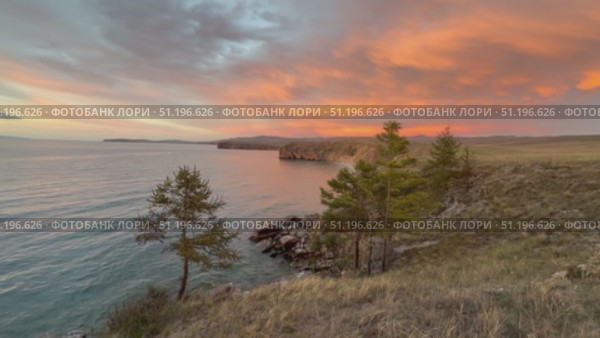 Video of beautiful sunset landscape of Baikal Lake with pink clouds over shore of Olkhon Island after rain. View of Small Sea on windy evening. Scenic landscape. Natural background. Summer travels. Стоковое видео, видеограф Виктория Катьянова / Фотобанк Лори