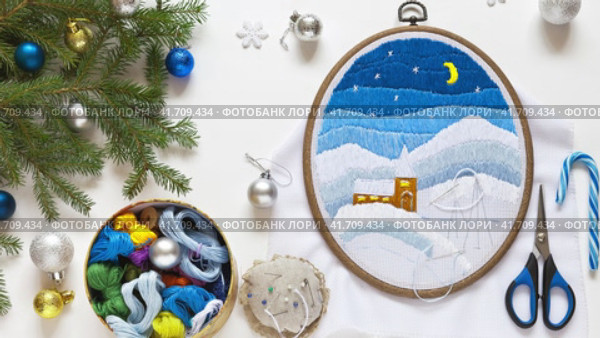 Video of preparing for Christmas. Making handmade gifts. Winter embroidery with long stitch. Christmas tree branches with colored balls on white background. DIY concept. Flat lay, close-up, top view. Стоковое видео, видеограф Виктория Катьянова / Фотобанк Лори
