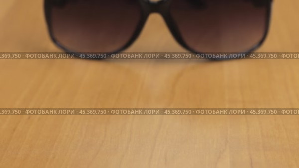 Видео со стильными женскими солнцезащитными очками. Снимок с тележки. Крупный план. Небольшая глубина резкости. Стоковое видео, видеограф Александр Собко / Фотобанк Лори