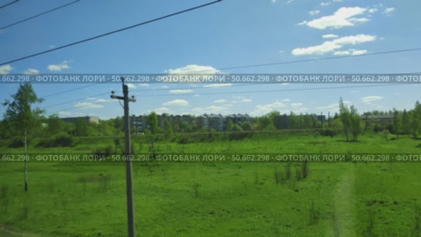 View from carriage window to natural expanses and small town. Fast-changing summer landscape seen from moving train. Стоковое видео, видеограф Ирина / Фотобанк Лори