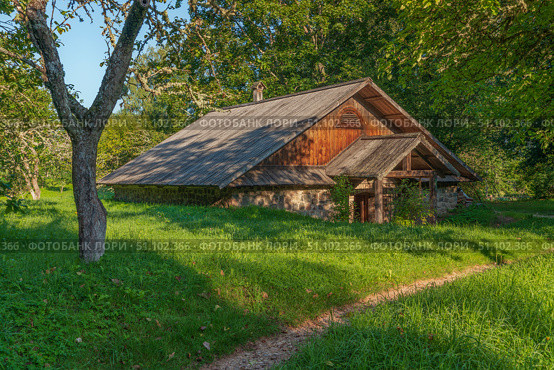 View of an old farm building on the territory of the Mikhailovskoye estate of the Pushkin State Museum-Reserve on a sunny summer day, Pushkinskiye Gory, Pskov region, Russia. Стоковое фото, фотограф Ula Ulachka / Фотобанк Лори