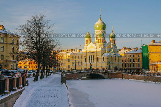 View of Saint Isidore's (Isidorovskaya) Church against the background of the Mogilev Bridge over the Griboyedov Canal on a sunny winter day, St. Petersburg, Russia. Стоковое фото, фотограф Ula Ulachka / Фотобанк Лори