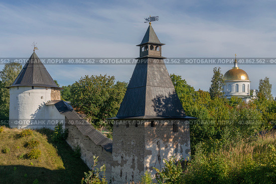 View of the outer wall of the Holy Dormition Pskov-Pechersk Monastery, the Tower of the Upper Lattices, the Khvostovsky Tower and St. Michael's Cathedral on a sunny summer day, Pechory, Pskov region, Russia. Стоковое фото, фотограф Ula Ulachka / Фотобанк Лори